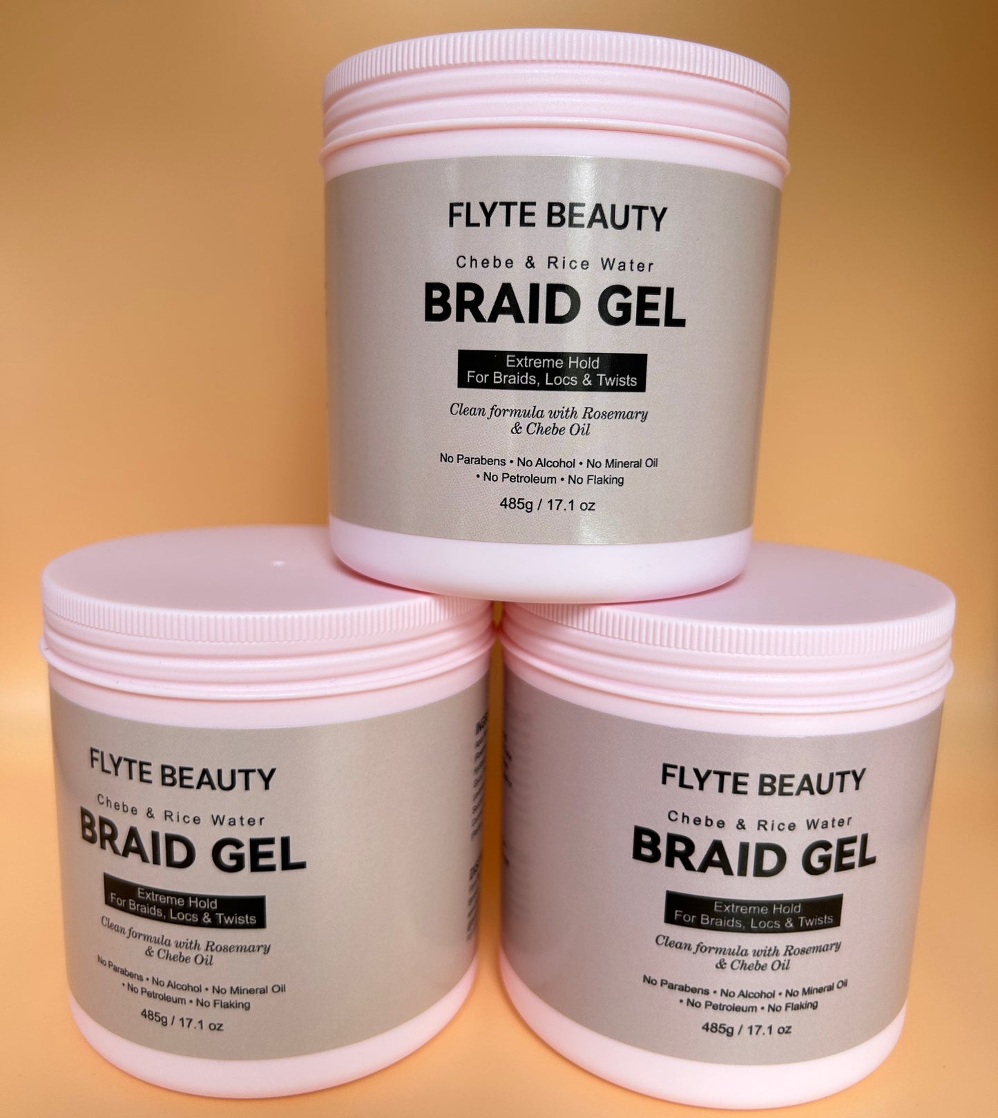 Three containers of Flyte Beauty Braid Gel stacked on a gradient background