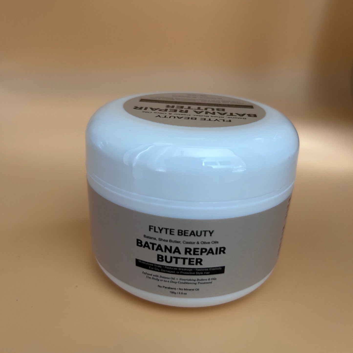 Jar of Flyte Beauty Batana Repair Butter on a beige background